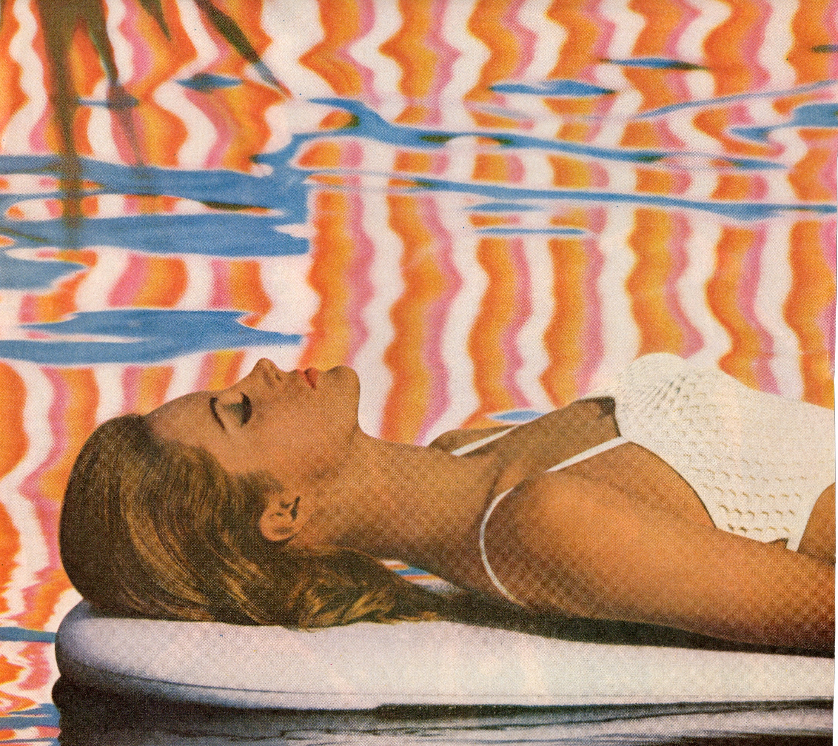 Woman lying on a towel with colorful water reflections in the background